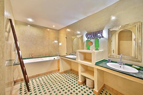 Riad Dar L'Oussia & SPA في الصويرة: حمام كبير مع مغسلتين وحوض استحمام ودوب