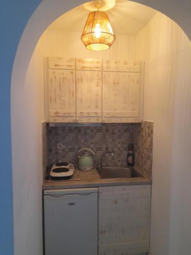 a small kitchen with a sink and a light at Kapares Studios in Agia Anna Naxos