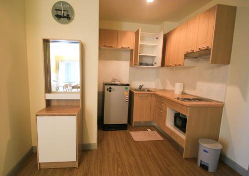 a kitchen with wooden cabinets and a refrigerator at Baan Rub Lom by Jane in Pak Chong