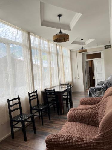 a living room with a table and chairs and windows at Manoni Ratiani's Hostel in Soli