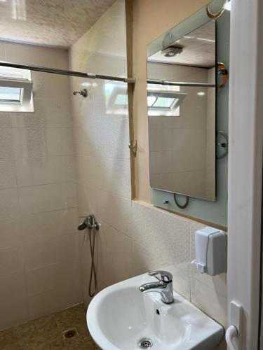 a bathroom with a sink and a mirror at Manoni Ratiani's Hostel in Soli
