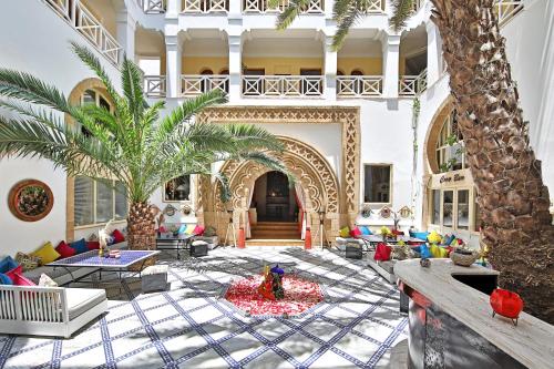 a living room with a palm tree in the middle at Riad Dar L'Oussia & SPA in Essaouira