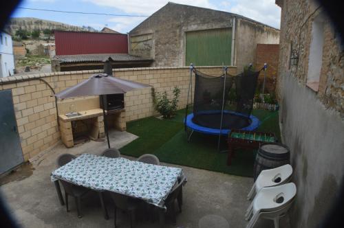 a small backyard with a table and a pool at Casa Rural El Convento in Valtierra