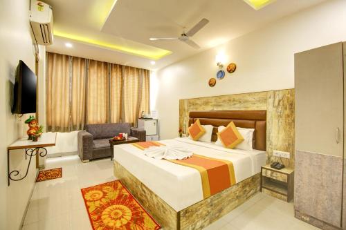 een hotelkamer met een bed en een bank bij Gracious by Vishesh Hotels & Home Stay in New Delhi