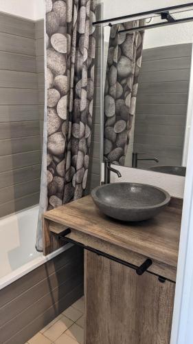 une salle de bain avec un lavabo et un rideau de douche dans l'établissement Climatisé, tout confort et belle vue apaisante, à Valras-Plage