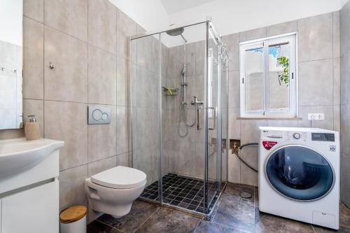 a bathroom with a toilet and a washing machine at Villa Oceano by Indigo in Carvoeiro