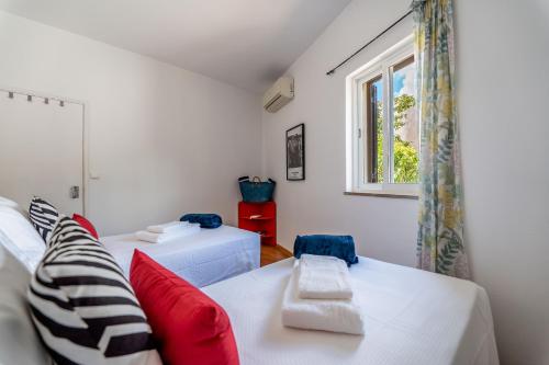 een woonkamer met 2 bedden en een raam bij Villa Oceano by Indigo in Carvoeiro