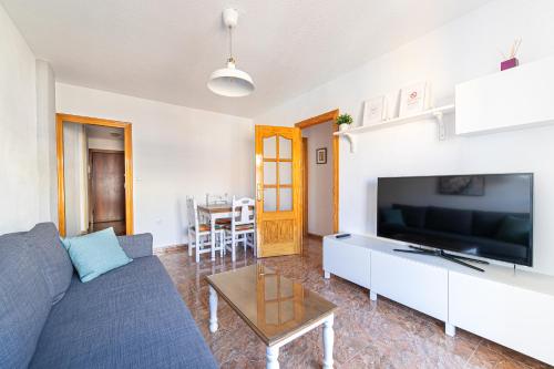a living room with a blue couch and a tv at Santomera 1st Line in Torrevieja