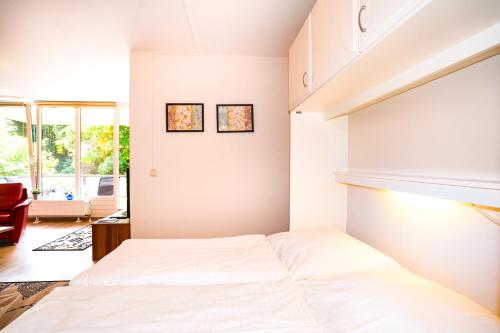 1 dormitorio con 1 cama blanca en una habitación en Fewo am Meer, mit Schwimmbad und Sauna, en Timmendorfer Strand