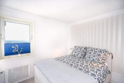 een witte slaapkamer met een bed en een raam bij Fewo Sommerliebe, mit Meerblick und Schwimmbad direkt am Hansapark in Sierksdorf