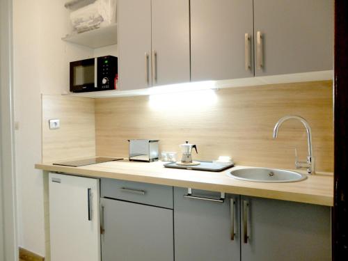 un comptoir de cuisine avec un évier et un micro-ondes dans l'établissement Studio lumineux proche des pistes avec WIFI - FR-1-502-436, à Tignes