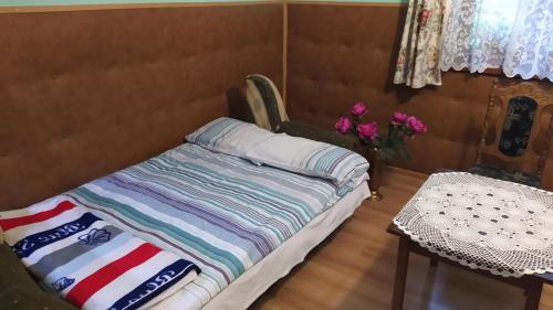 1 dormitorio con 1 cama, mesa y flores en Grill nad Potokiem, en Grybów