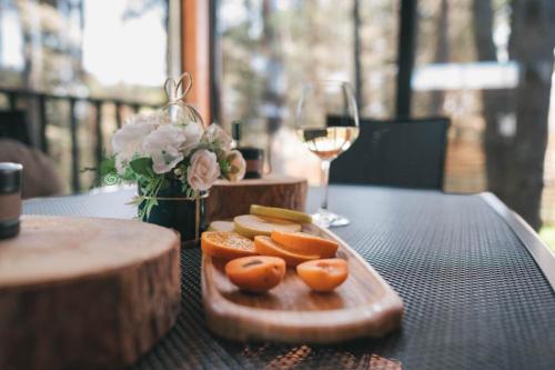 a tray of fruit on a table with a glass of wine at Dakota forest retreat in Tsigov Chark