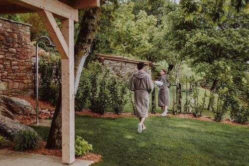 two women walking through a garden with a fence at FAVAI HILLS your secret hideaway in Brenzone sul Garda