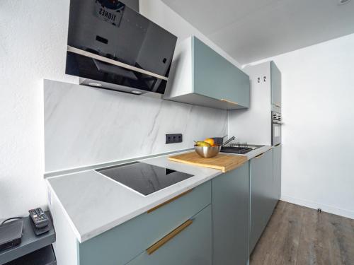 une cuisine blanche avec un évier et un micro-ondes dans l'établissement Studio Confortable à Tignes · Skis aux Pieds · Balcon · WiFi Inclus · Tarif Forfaits Préférentiel - FR-1-502-524, à Tignes