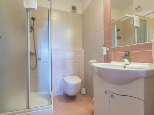 a bathroom with a sink and a toilet and a shower at Villa Tomko in Brovinje