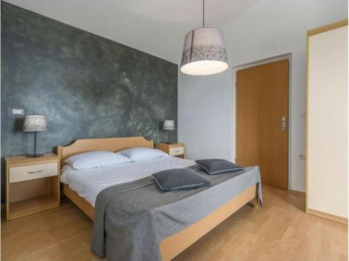 a bedroom with a bed and a large wall at Villa Tomko in Brovinje