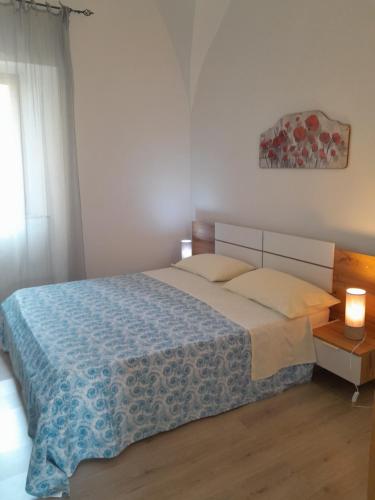 um quarto com uma cama grande e um cobertor azul em Casa vicino al mare em Piombino