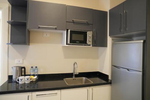 a small kitchen with a sink and a refrigerator at Villa 55 in 6th Of October