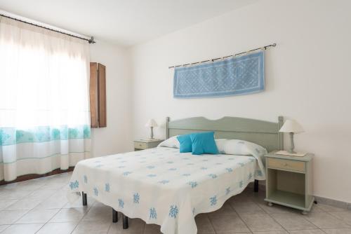 Schlafzimmer mit einem Bett, einem Tisch und einem Fenster in der Unterkunft Hotel Biderrosa in Cala Liberotto