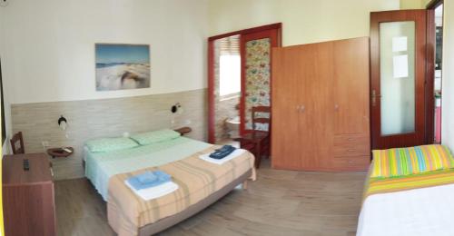 a bedroom with a bed and a closet and a door at Casa Vacanze"Il Bouganville" in Carbonia