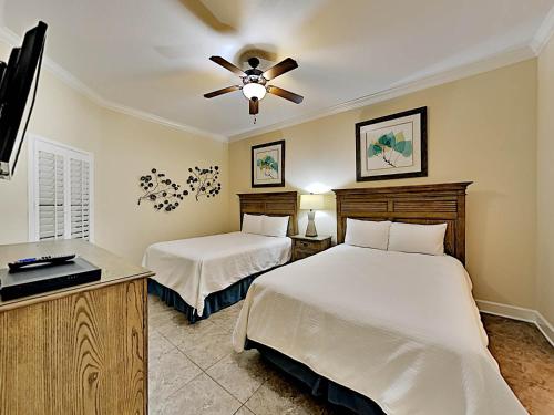 a bedroom with two beds and a ceiling fan at Phoenix West II #2109 in Orange Beach