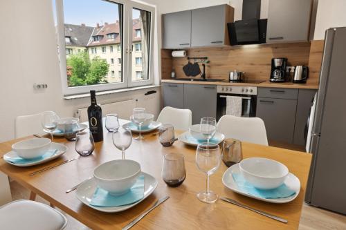 - une table à manger avec des verres et une bouteille de vin dans l'établissement Große 80qm 3 Zimmer Wohnung, nahe Messe & Klinikum, 2x 55" Smart TV, Netflix, Keyless, à Essen