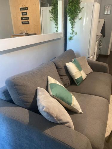 a brown couch with pillows sitting in a room at studio ponant avec parking climatisé in La Grande-Motte