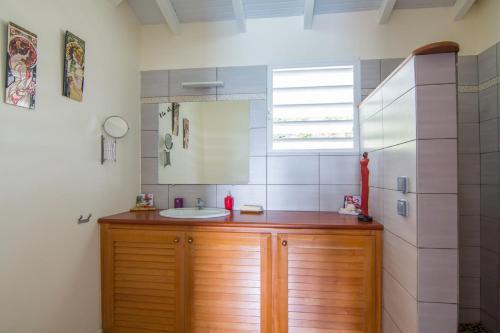 a bathroom with a wooden vanity with a sink at Villa La Favorite in Capesterre-de-Marie-Galante