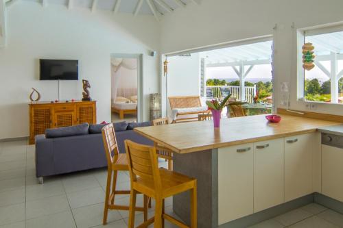 a kitchen and living room with a table and chairs at Villa La Favorite in Capesterre-de-Marie-Galante