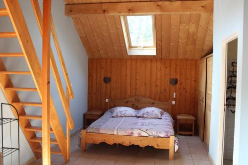 a bedroom with a bed with a wooden ceiling at Gîte l'essentiel in Arc-sous-Cicon