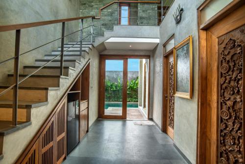 a hallway of a house with stairs and a pool at Ubud Diary Villa in Ubud