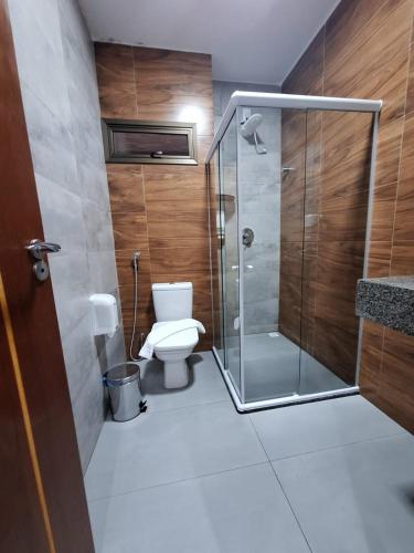 a bathroom with a toilet and a glass shower at Hotel Reserva do Xingó in Piranhas