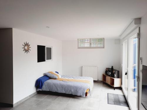 a bedroom with white walls and a bed in it at Appartement Cosy chez Nicolas et Aline in Pompiey