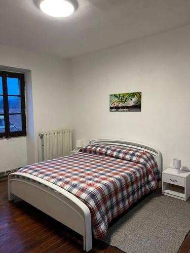 een slaapkamer met een bed met een geruite deken bij Cascina “La Bizzarina” in Castelletto sopra Ticino