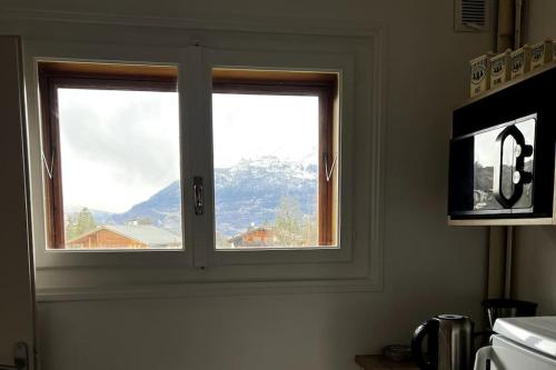a window in a kitchen with a view of a mountain at Appartement dans chalet - 75 m2 - 4 à 6 personnes in Saint-Gervais-les-Bains
