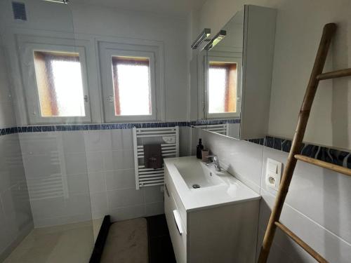 a white bathroom with a sink and a mirror at Appartement dans chalet - 75 m2 - 4 à 6 personnes in Saint-Gervais-les-Bains
