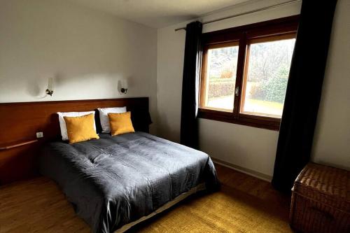 a bedroom with a bed with yellow pillows and a window at Appartement dans chalet - 75 m2 - 4 à 6 personnes in Saint-Gervais-les-Bains