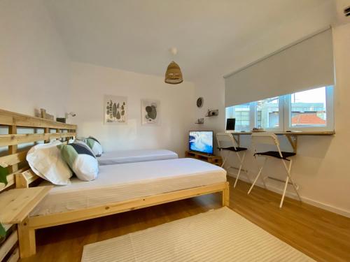 - une chambre avec un lit et un bureau avec une télévision dans l'établissement Lucas Central Oasis Studios, à Tirana