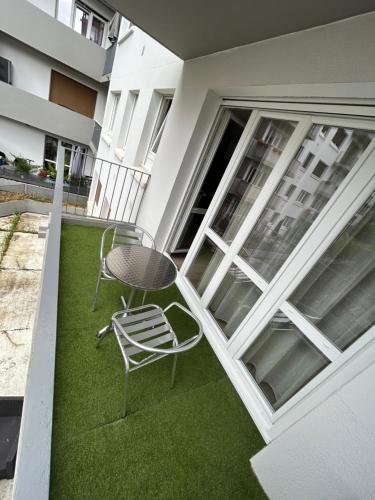 un patio con tavolo e sedia sul balcone di Les chambres du Graoully - Le 136 - Metz Queuleu - Place de parking intérieur a Metz