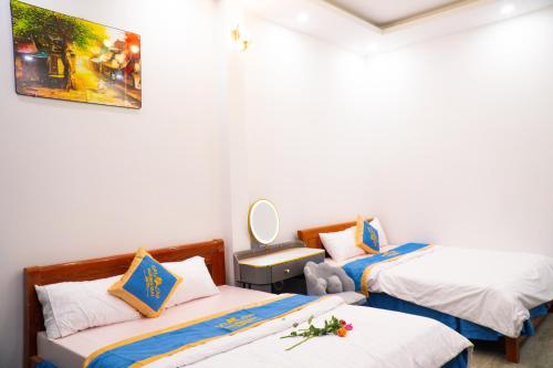 a room with two beds and a mirror at Huong Mai Hotel in Da Lat
