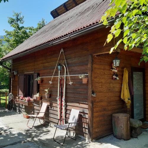 a log cabin with two chairs and a table at Cabana Bradut Borsa in Statjunea Borsa