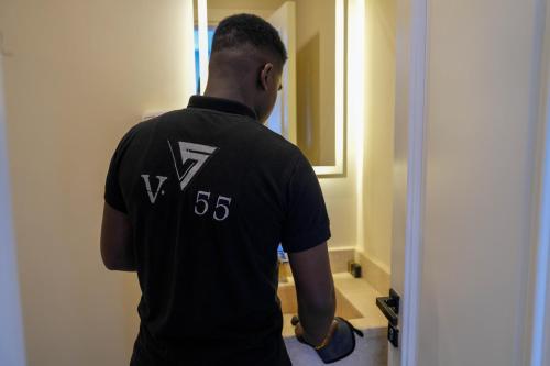a man standing in a hallway looking into a mirror at Villa 55 in 6th Of October