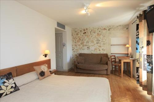 a room with a bed and a couch and a table at Domaine Les Mejeonnes in Valaurie