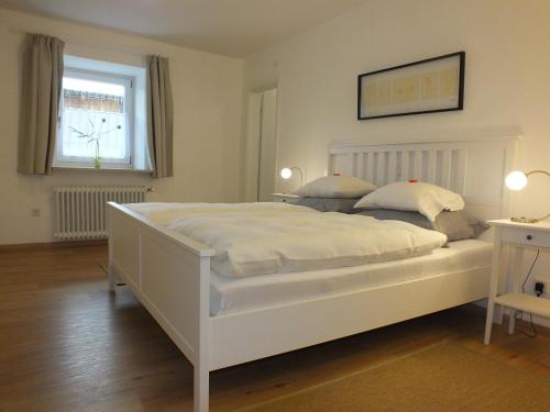 a large white bed in a room with a window at Ferienwohnung Aumühle in Freilassing