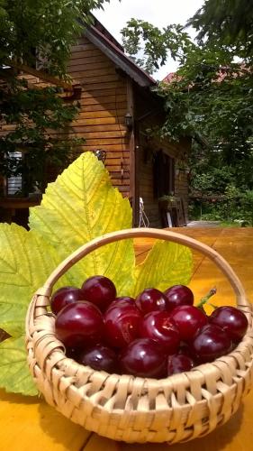 a basket of red fruit with leaves in it at Cabana Bradut Borsa in Statjunea Borsa