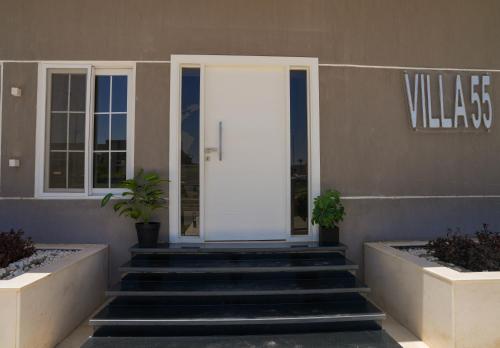 a white door on the side of a building with stairs at Villa 55 in 6th Of October