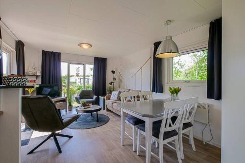 a kitchen and living room with a table and chairs at Chalet Riviéra - Camping De Watersnip Sint Maartenszee in Petten