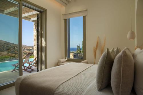 a bedroom with a large bed with a view of the ocean at Casa Di Fiori Andros Suites in Andros