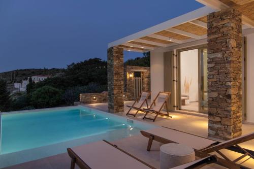 a villa with a swimming pool at night at Casa Di Fiori Andros Suites in Andros